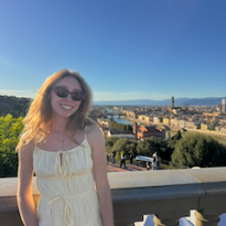 A girl smiling at the top of the Piazzale Michelangelo with a view of Florence in the background