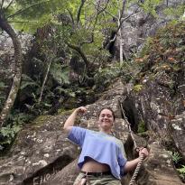 Pono posing in front of the rock climb up to Raemaru summit.