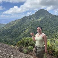 Pono at the top of the Te Rua Manga outlook with other mountains in the background.