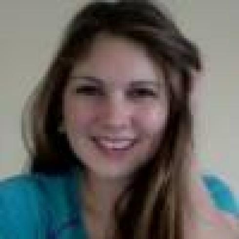 Smiling woman with long hair in bright sunlight. This alt text was added with Al; accuracy may vary.