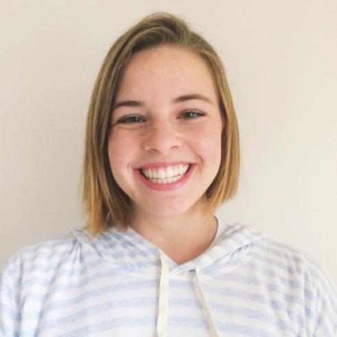 Four women smiling in individual portraits with neutral backgrounds. This alt text was added with Al; accuracy may vary.