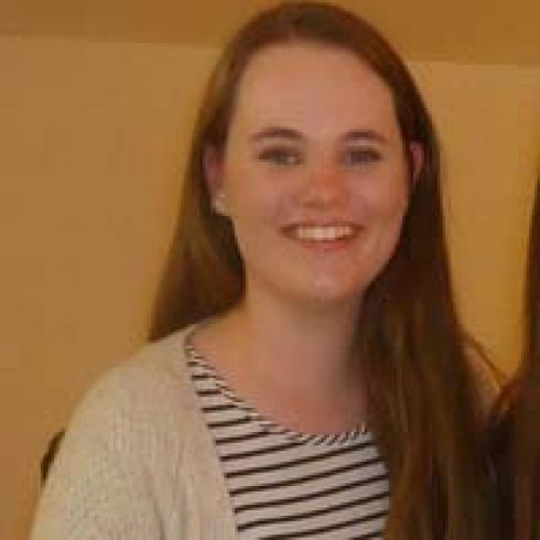 Smiling person in a casual setting, light background. This alt text was added with Al; accuracy may vary.