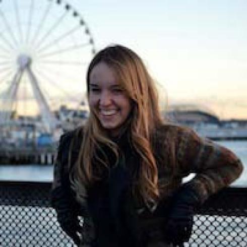 Smiling person with dark hair and a blue shirt in a bright setting. This alt text was added with Al; accuracy may vary.