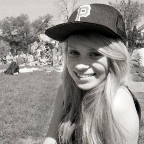 1. Smiling woman at sunset overlooking a city.
2. Woman smiling against a neutral background.
3. Cityscape at dusk with a silhouetted tower and pink sky.
4. Woman leaning forward in a cozy, decorated room.
5. Smiling woman in a baseball cap outdoors in black and white. This alt text was added with Al; accuracy may vary.