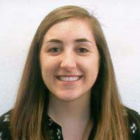 Silhouette of person with arms outstretched on a rocky shore at sunset. This alt text was added with Al; accuracy may vary.