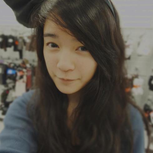 Young woman with long hair, wearing a large black bow. This alt text was added with Al; accuracy may vary.