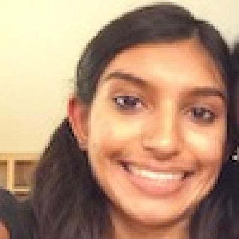 Smiling person with long hair, indoors. This alt text was added with Al; accuracy may vary.