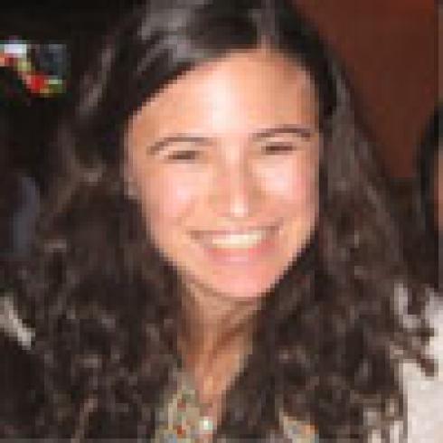 Riverside scene with trees, people, and a church tower under a clear blue sky. This alt text was added with Al; accuracy may vary.