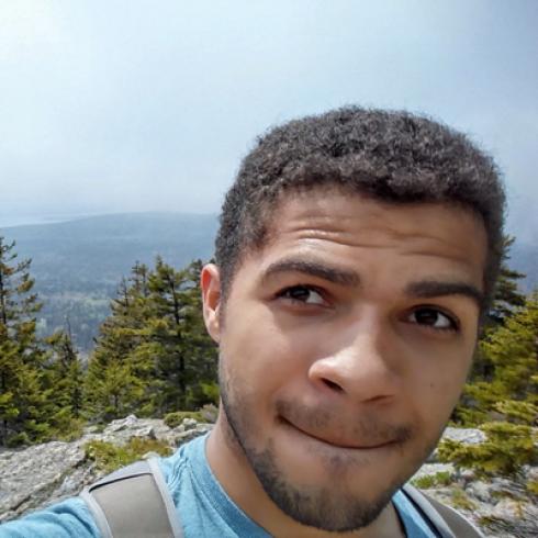 Person smiling against a plain background. This alt text was added with Al; accuracy may vary.