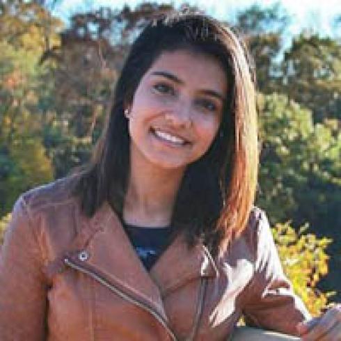A group of people standing on a beach with the ocean in the background. This alt text was added with Al; accuracy may vary.
