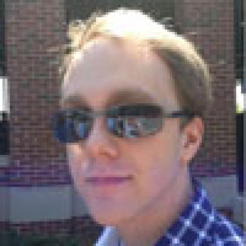 Young woman smiling at a toucan on her shoulder; man in sunglasses with a brick wall background. This alt text was added with Al; accuracy may vary.