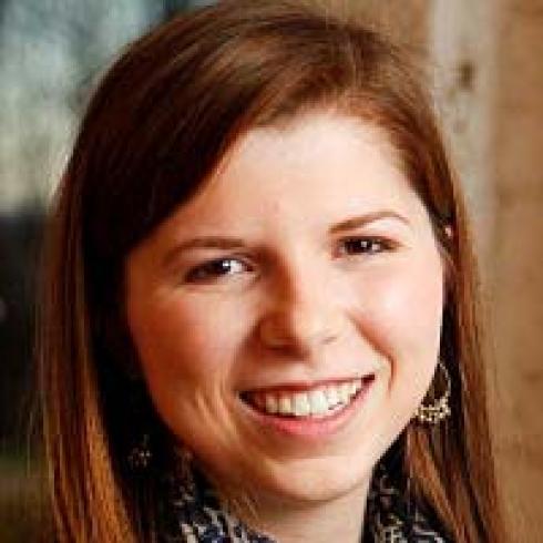 Photo of a smiling woman with long hair outdoors. This alt text was added with Al; accuracy may vary.