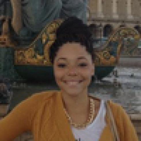 Group at mountain viewpoint wall smiles at camera against blue sky. This alt text was added with Al; accuracy may vary.