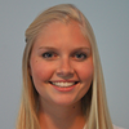 Blonde woman smiling with a blurred background. This alt text was added with Al; accuracy may vary.