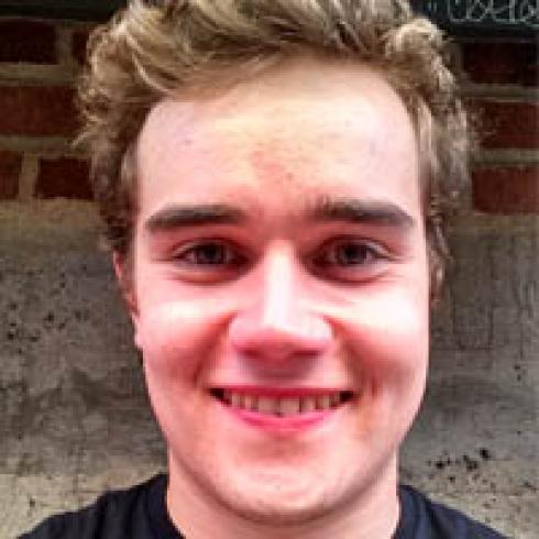 Landscape at sunset with distant factory and calm sea. This alt text was added with Al; accuracy may vary.