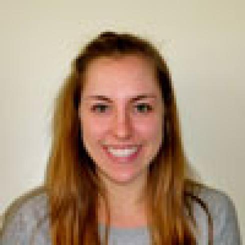 Smiling woman with long hair against a blurred background. This alt text was added with Al; accuracy may vary.