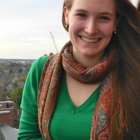 Smiling woman outdoors, wearing a green shirt and patterned scarf. This alt text was added with Al; accuracy may vary.