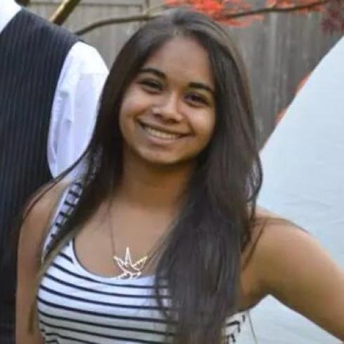 Smiling person in a striped top outdoors. This alt text was added with Al; accuracy may vary.