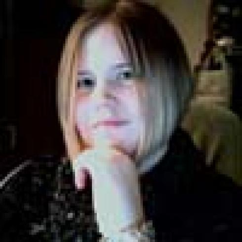 Smiling person with glasses outdoors. This alt text was added with Al; accuracy may vary.