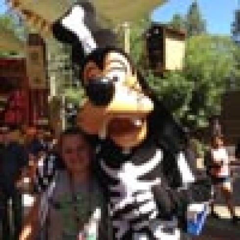 Goofy in a skeleton costume hugging someone at a theme park. This alt text was added with Al; accuracy may vary.