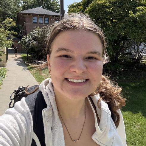 Maggie Erickson smiling outside in front of trees.