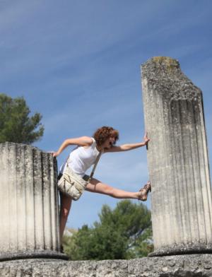 a student poses between two column ruins in Arles