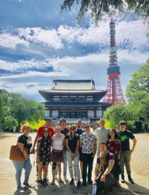 students posing for a photo in front of Tokyo Tower and a Japanese palace