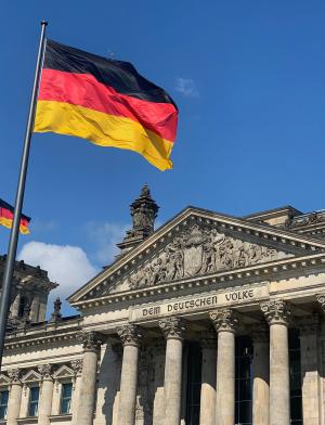 the German flag waving in front of Bundestag in Berlin