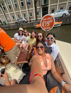 six girls pose for a photo on a canal tour of Amsterdam