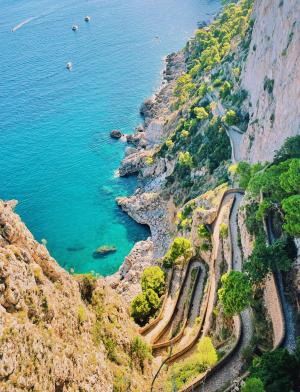 A view off of a cliff's edge of the ocean in Italy.