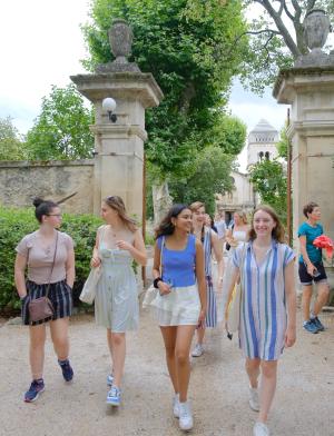 A group of students walk together down a road in Saint Rémy de Provence, France.