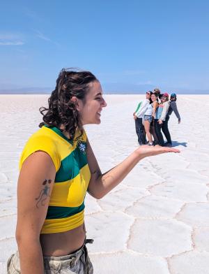 one student is in the foreground of the photo holding out their hand, while a group of students in the distance appear to be in her hand in Salta