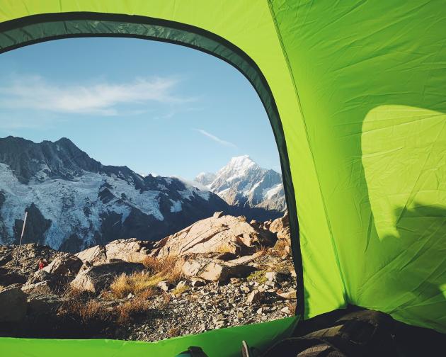 a view of snowcapped mountains from inside a tent in New Zealand