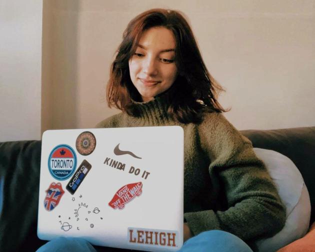 Intern sitting on a couch with a laptop in her lap