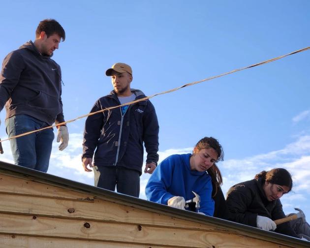 students working with TECHO to build homes for those in need