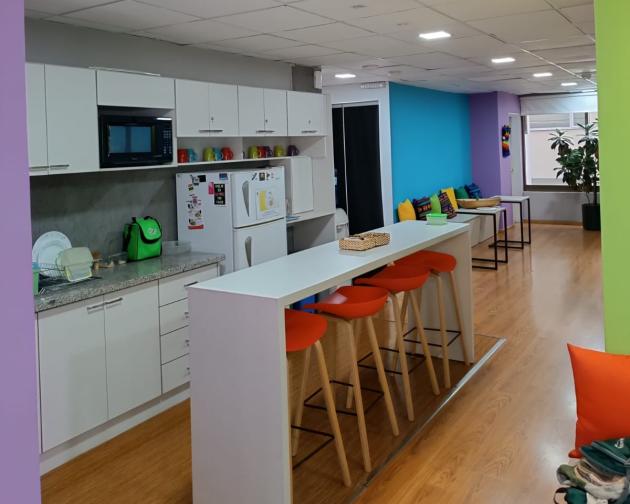 A photo of the inside of our colorful and vibrant Center in Quito, featuring a kitchenette and seating area