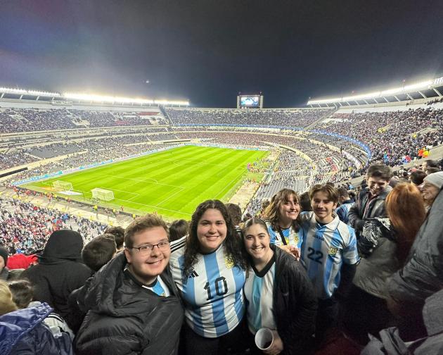 A group of students pose for a photo while at an Argenina futbol game