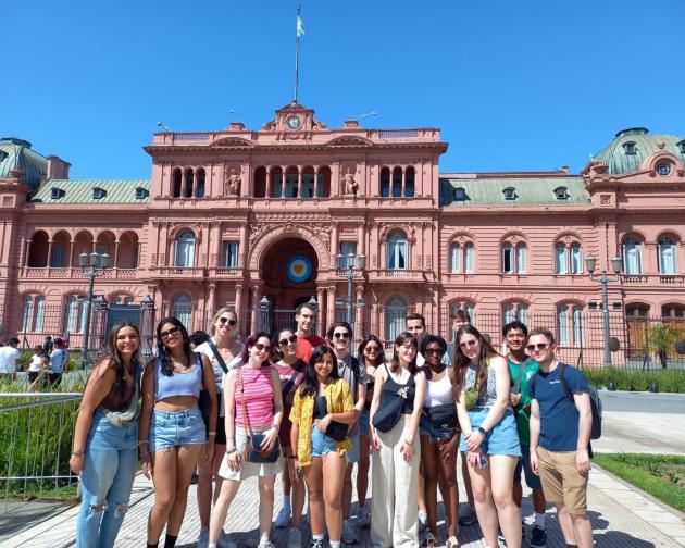 A group of students pose for a photo in front of La Casa Rosada, Argentina's capitol building