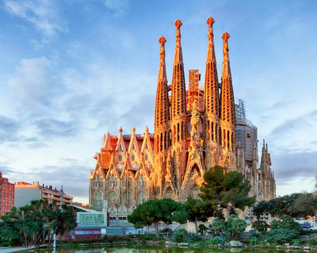 The iconic Sagrada Familia in Barcelona, bathed in golden light, with its towering spires and intricate architecture.
