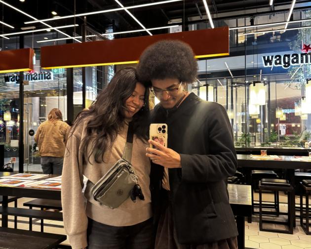 Two people taking a photo in a mirror