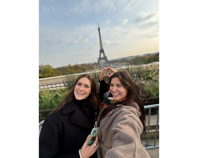 2 girls posing for a selfie in front of Eiffel tower in paris