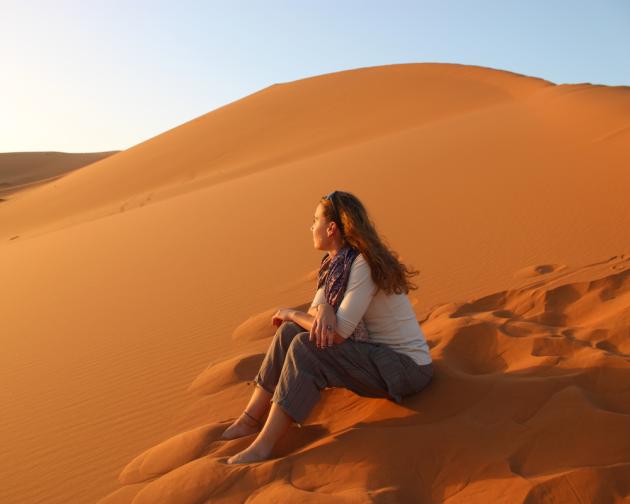 Student looking out into the distance while sittin gin the Sahara Desert