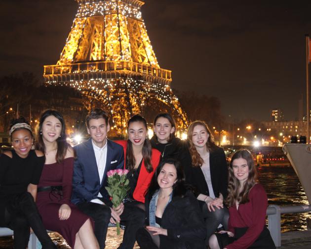 Students dressed up in front of Eiffel Tower at Night
