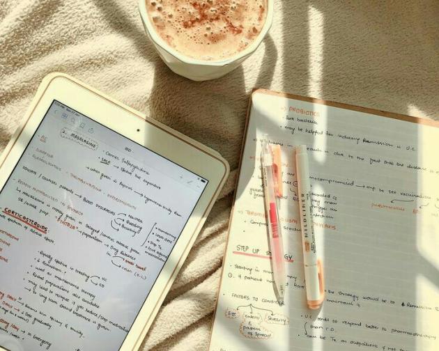 Cup, book and Ipad on a white sheet