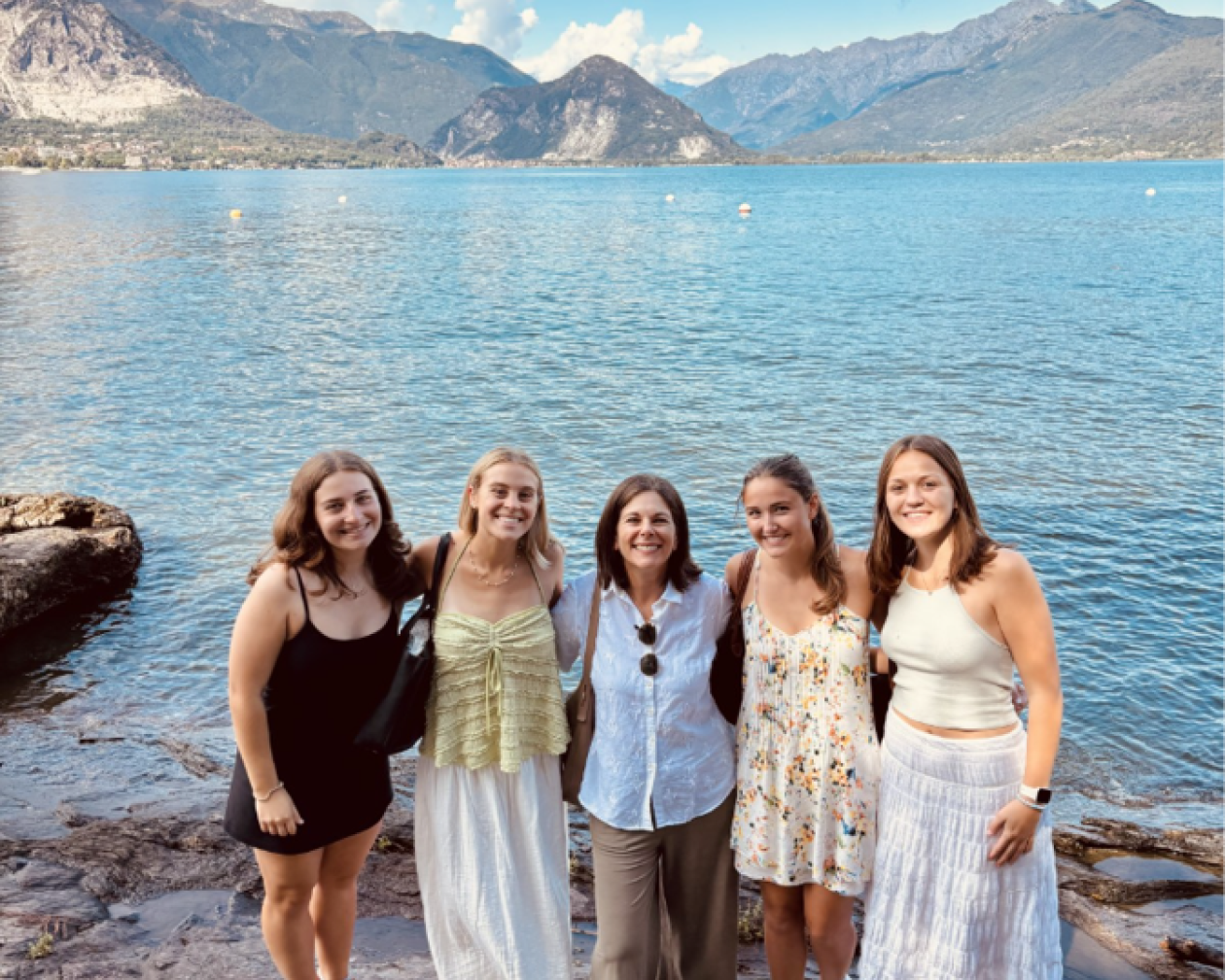 Five individuals standing in front of Lake Maggiore in Stresa, Italy