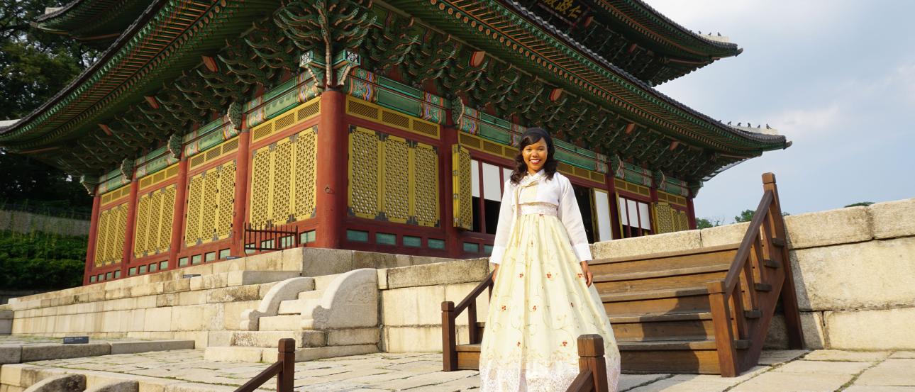 a student poses for a photo in traditional Korean hanbok in front of Changgyeonggung Palace