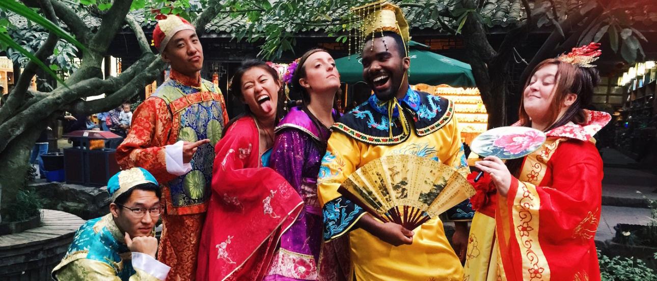 a group of students pose for a fun photo wearing traditional Chinese garments
