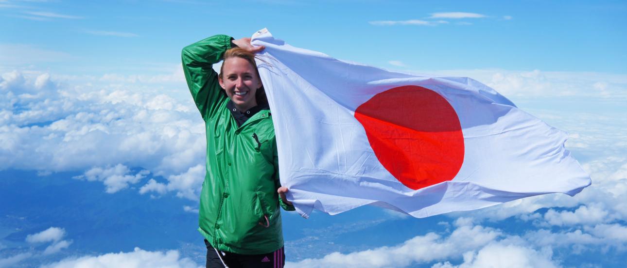 a student flies the Japanese flag at the top of Mount Fuji