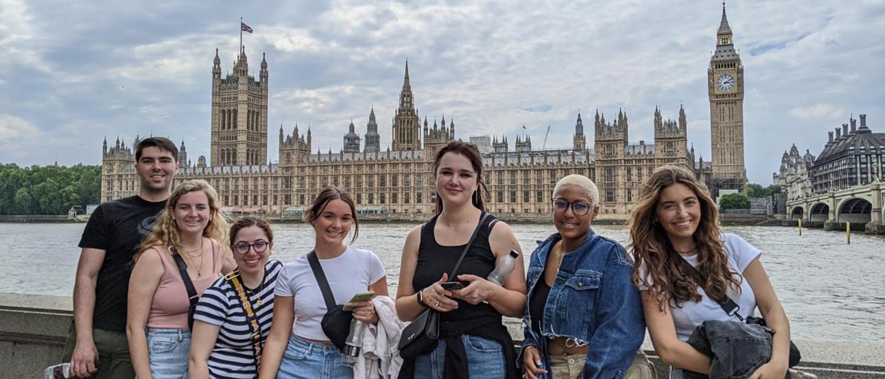 A group of students posing for a photo in front of British Parliament and the River Thames