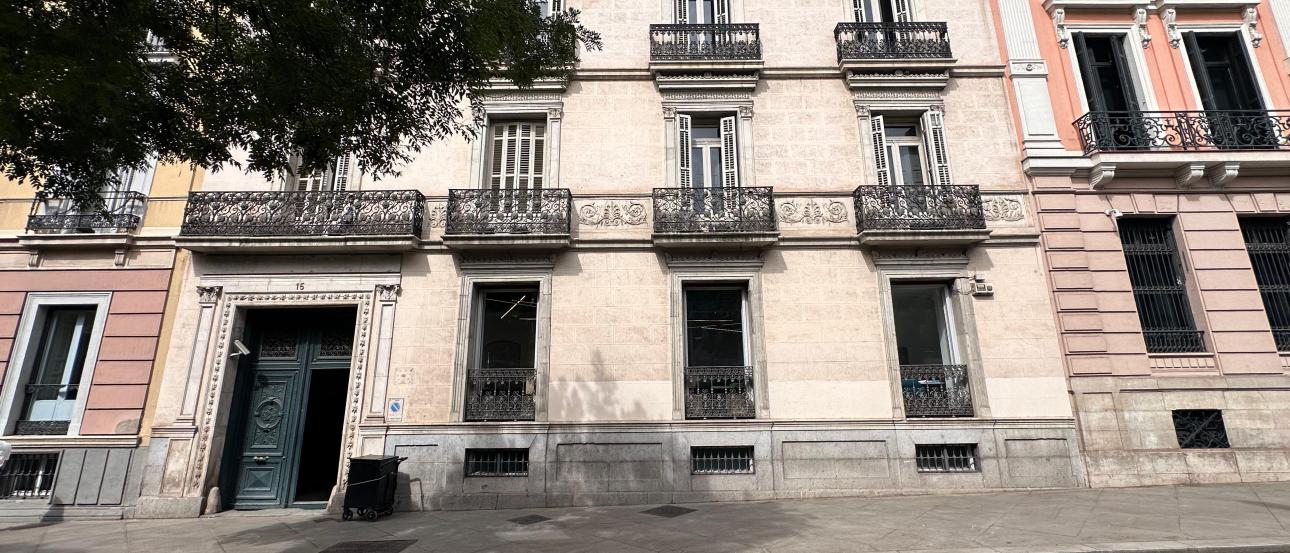 A building exterior with wrought iron balconies and an elaborate door